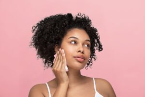 Une femme métissée qui applique le produit cosm'ethique